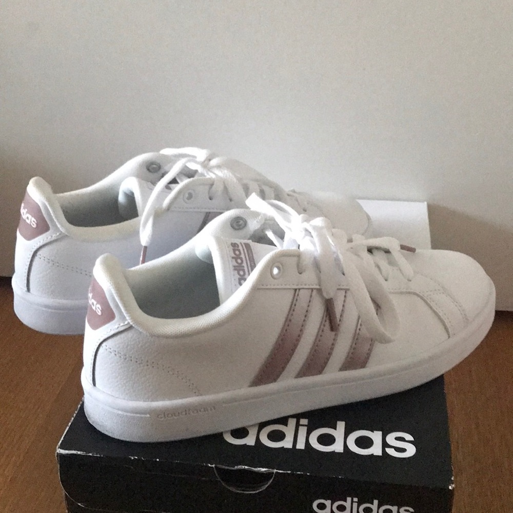 Women’s ADIDAS sneakers with rose gold stripes.